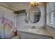 Cozy bathroom featuring an oval mirror, a shower with a curtain, and modern fixtures at 7809 Alafia Dr, Riverview, FL 33578