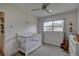 This Bedroom contains a crib and dresser with a view to the window and ceiling fan at 7809 Alafia Dr, Riverview, FL 33578