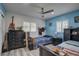 Cozy bedroom with blue accent wall, ceiling fan, and natural light from multiple windows at 7809 Alafia Dr, Riverview, FL 33578