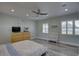 Light-filled bedroom with gray flooring, ceiling fan, and a wall decor that spells 'ANOTHER LOVE' at 7809 Alafia Dr, Riverview, FL 33578