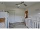 This Bedroom contains a crib with a view into the hall and includes a ceiling fan at 7809 Alafia Dr, Riverview, FL 33578