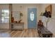 Inviting entryway featuring a blue door, wood floors, and stylish console tables at 7809 Alafia Dr, Riverview, FL 33578