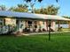 Inviting front porch with rocking chairs, a swing, decorative shutters, and well-maintained landscaping at 7809 Alafia Dr, Riverview, FL 33578