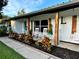 Charming front porch with rocking chairs, a swing, decorative shutters, and colorful landscaping at 7809 Alafia Dr, Riverview, FL 33578
