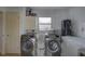 Laundry room with washer, dryer, water heater, storage cabinet and an additional freezer at 7809 Alafia Dr, Riverview, FL 33578