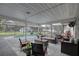 Comfortable outdoor living with screened patio, wicker seating, and scenic views of the sparkling pool at 7809 Alafia Dr, Riverview, FL 33578