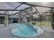 Large screened-in pool with a diving board and a view of the landscaped backyard and patio at 7809 Alafia Dr, Riverview, FL 33578