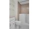 Bathroom with tile shower, toilet, and glass shelves at 9 Haig Pl # 612, Dunedin, FL 34698