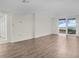 Bright living room with wood-look floors and access to a balcony at 9 Haig Pl # 612, Dunedin, FL 34698