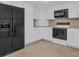 Bright kitchen with white cabinets, black appliances, and tile flooring at 9 Haig Pl # 612, Dunedin, FL 34698