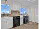 Modern kitchen with white cabinets, black appliances and water views at 9 Haig Pl # 612, Dunedin, FL 34698