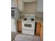 Basic kitchen with white appliances and light wood cabinets at 6100 12Th S St # 211, St Petersburg, FL 33705