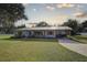 White house with covered porch, landscaped yard, and a long driveway at 7809 Alafia Dr, Riverview, FL 33578