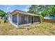 A screened porch overlooks a fenced backyard with mature trees at 9406 Rainbow Ln, Port Richey, FL 34668