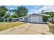 Front view of a house with a gray stone facade and a driveway at 9406 Rainbow Ln, Port Richey, FL 34668