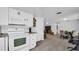 Open concept kitchen with white cabinets, granite counters, and view into dining area at 9406 Rainbow Ln, Port Richey, FL 34668