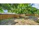 Fenced backyard with a large tree providing shade at 9406 Rainbow Ln, Port Richey, FL 34668