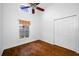Bedroom with hardwood floors, ceiling fan and double door closet at 1008 Blue Heron Way, Tarpon Springs, FL 34689