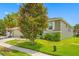 House exterior showcasing a landscaped lawn and a two-car garage at 1008 Blue Heron Way, Tarpon Springs, FL 34689
