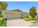 House exterior featuring a two-car garage and well-manicured lawn at 1008 Blue Heron Way, Tarpon Springs, FL 34689