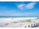 Expansive view of the sandy beach with blue water and clear skies at 14300 Gulf Blvd # 206, Madeira Beach, FL 33708
