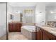 Elegant bathroom with a soaking tub and granite countertops at 1008 Blue Heron Way, Tarpon Springs, FL 34689