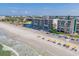 Aerial view showcasing beachfront building and beach umbrellas at 14300 Gulf Blvd # 206, Madeira Beach, FL 33708