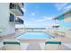 Community pool with lounge chairs at 14300 Gulf Blvd # 206, Madeira Beach, FL 33708