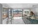 Casual dining area with glass-top table and chairs, adjacent to a sunroom with water views at 11220 9Th E St, Treasure Island, FL 33706
