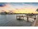 Serene waterfront view at sunset with a private dock and neighboring properties at 11220 9Th E St, Treasure Island, FL 33706