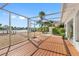 Spacious back patio with a screened enclosure and wooden deck overlooking the water at 11220 9Th E St, Treasure Island, FL 33706