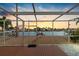 Scenic waterfront view at sunset, featuring a private dock and neighboring houses at 11220 9Th E St, Treasure Island, FL 33706