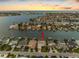 An aerial view showcasing a waterfront home with its private dock and a beautiful sunset at 11220 9Th E St, Treasure Island, FL 33706