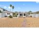 Landscaped backyard with a pathway leading to the waterfront at 11220 9Th E St, Treasure Island, FL 33706