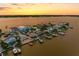 Aerial view of a waterfront community at sunset, showcasing various properties and boats at 11220 9Th E St, Treasure Island, FL 33706
