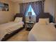 Guest bedroom with two twin beds and neutral decor at 3912 Fontainebleau Dr, Tampa, FL 33634