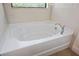 Oval-shaped bathtub with chrome faucet and tiled surround at 15250 Anguilla Isle Ave, Tampa, FL 33647