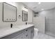 Modern bathroom with double vanity, gray cabinets, and a frameless shower enclosure at 5542 Atlantic N Ave, St Petersburg, FL 33703