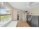 Bright laundry room with modern washer and dryer, storage shelves, and a large window at 6240 Bayside Dr, New Port Richey, FL 34652