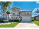 Tan two-story house with attached garage and landscaping at 6240 Bayside Dr, New Port Richey, FL 34652