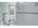 Clean bathroom with white tile, shower/tub combo, and window at 516 Gulf Blvd, Indian Rocks Beach, FL 33785