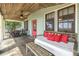 Inviting porch with wooden flooring, seating area, and outdoor dining set at 516 Gulf Blvd, Indian Rocks Beach, FL 33785