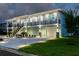 Two-story house with lighted staircase and landscaping at 83 Palm Blvd, Dunedin, FL 34698