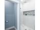Walk-in shower with white tile and stone accent wall at 83 Palm Blvd, Dunedin, FL 34698