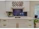 Modern wet bar with white cabinets, gold accents, and hexagon tile backsplash at 5511 13Th N Ave, St Petersburg, FL 33710