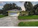 House exterior featuring a yellow ranch-style home with a white garage door and well-maintained lawn at 498 Bayview Ne Dr, St Petersburg, FL 33704