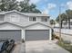 Gray two-story townhouse with attached garage and landscaped front yard at 9247 Jakes Path, Largo, FL 33771
