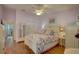 Lavender bedroom with floral bedding, hardwood floors, ceiling fan, and walk-in closet at 9247 Jakes Path, Largo, FL 33771