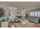Spacious living room with light blue sofas, hardwood floors, ceiling fan and large windows at 9247 Jakes Path, Largo, FL 33771