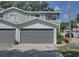 Gray two-story townhouse with attached garage and landscaped front yard at 9247 Jakes Path, Largo, FL 33771
